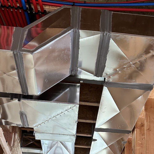 Sheet metal seam and hanger detail on a duct trunk line